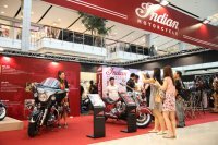 A few girls taking pictures of themselves at the Indian Motorcycles at the Bangkok Motorbike Festival 2014